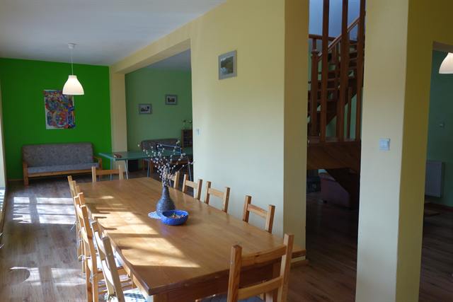 Salon z wielkim stołem widziany od strony kuchni